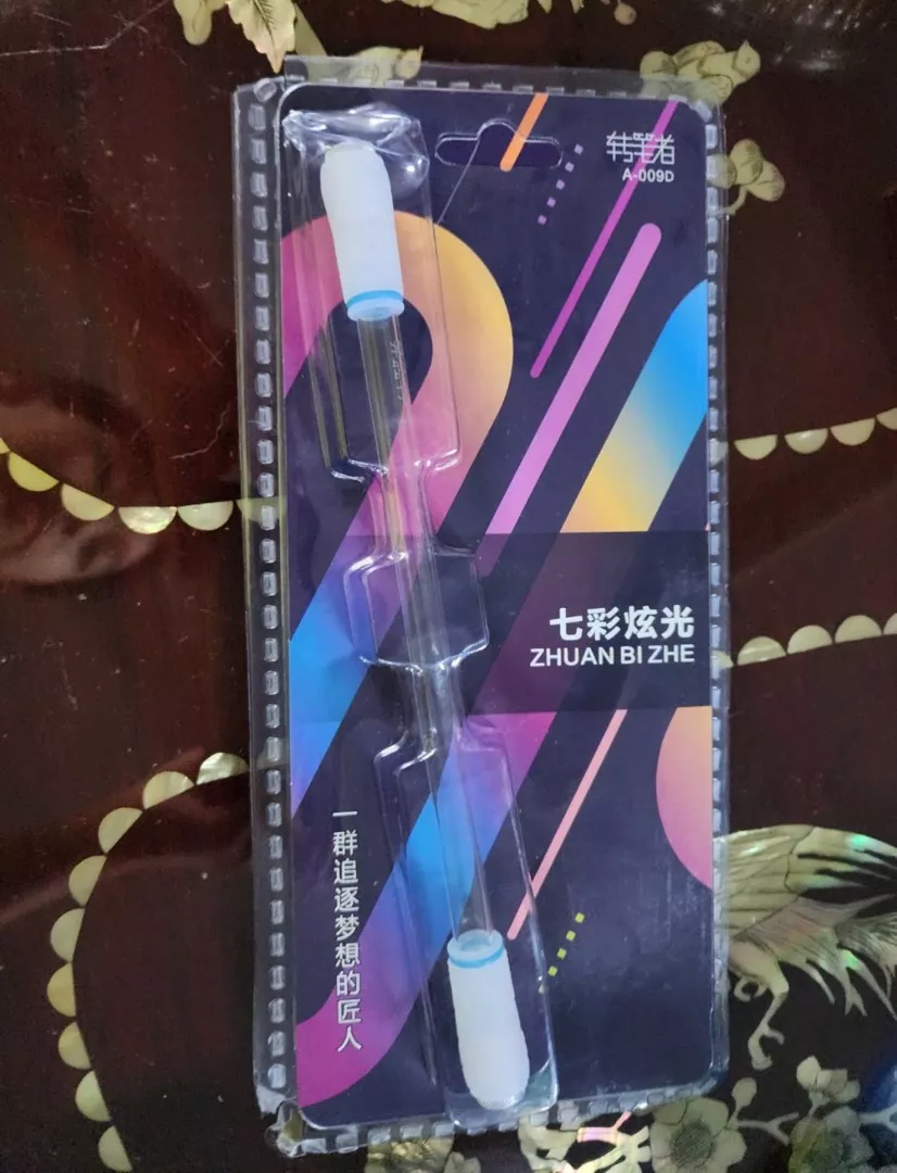 ปากกาควงมีไฟ แบบใส ในแพ็กเกจ วางบนผ้าปูโต๊ะ รีวิวจากลูกค้า ST0007